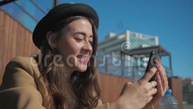 快乐的黑发女人阅读短信和观看图片在智能手机，特写