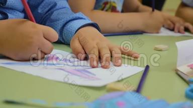 幼儿在幼儿园做图纸.. 手的儿童特写.. 孩子们`创造力。 团队合作。