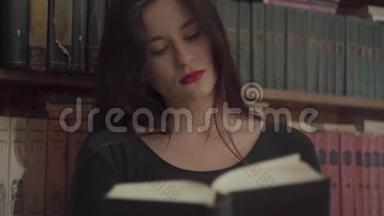 一个疲惫的年轻学生的肖像，她的妆容鲜艳，站在<strong>书架前</strong>的图书馆里<strong>看书</strong>。 概念