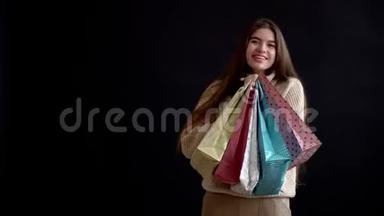 可爱的女孩白种人的外表紧紧地抱着一大堆五颜六色的礼品袋。