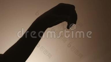 一个女人手里拿着一缕头发从头上掉下来的剪影。