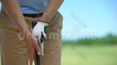 有经验的男子高尔夫球手戴着白色手套，手持铁棍准备进行<strong>体育比赛</strong>