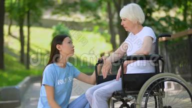 女志愿者安慰哭哭啼啼的老太太轮椅，老年残疾，帮助