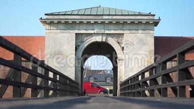 通往鸽子飞翔的老城的大门和桥。 红色汽车靠近大门。