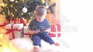 可爱的小男孩在<strong>圣诞</strong>树前用球和灯看动画片。 准备<strong>迎</strong>接新年的孩子