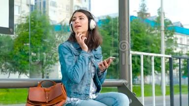 在现代公共汽<strong>车站</strong>听音乐的女孩