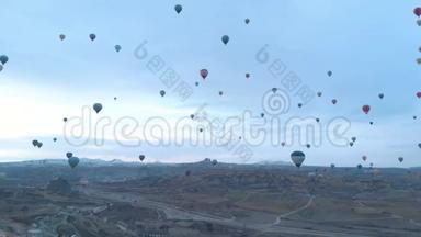 <strong>土耳其</strong>卡帕多西亚日出时，天空晴朗，天空中有许多<strong>热气球</strong>的空中山谷景观