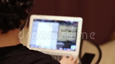 男人坐在模糊的笔记本电脑前，从背面看拷贝空间