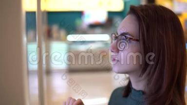 一位年轻女子在购物中心的触摸<strong>终端</strong>点菜。 现代技术。 在食品法庭上