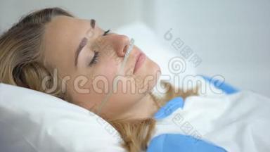 带着氧气鼻插管的哭女看着摄像机，在手术前担心