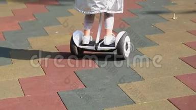 在城市公园户外的儿童游乐场里，一个可爱的学龄前女孩骑着白色的小黑板