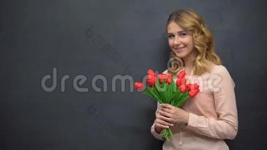 年轻女子拿着鲜花站在黑板旁，庆祝<strong>教师节</strong>