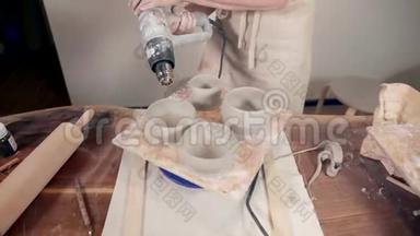 女人在陶艺工作室用现代技术烘干陶罐