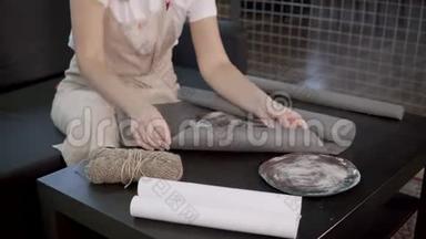 工艺陶工女士将独家手工制作的陶瓷盘子包在纸上