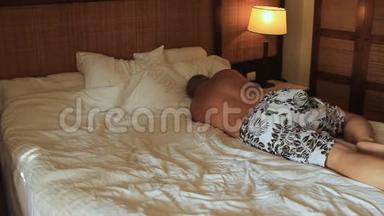 一个男人躺在一家铺着白色<strong>床单</strong>的旅馆的床上，准备睡觉