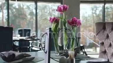 用餐巾纸和餐具在餐厅用餐。 餐桌上的鲜花