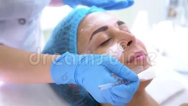 专业美容师和皮肤科医生在美容院用面膜敷脸。 紧缩和调整程序
