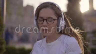有趣的少女用耳机听音乐，用4K唱歌