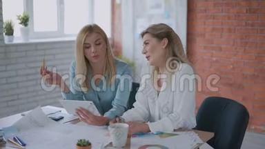 两名妇女正在从事一个项目。 女孩们在平板电脑上<strong>看报</strong>告。 现代办公，团队合作理念。 4K