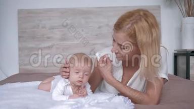 母亲带着女儿为躺在床上的相机摆姿势，父母轻轻地亲吻和拥抱她的新生女孩