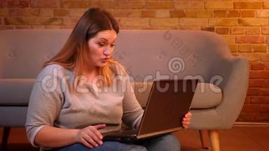 此外，尺寸模型坐在地板上，在笔记本电脑上的视频聊天，在舒适的家庭氛围中体贴。