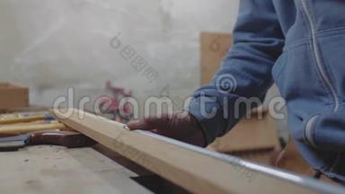 用卷尺测量木板的工人手的特写，用铅笔记录。 。 4k. 4k录像。 慢慢慢慢