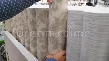 女人在DIY商场的五金店里选择壁纸