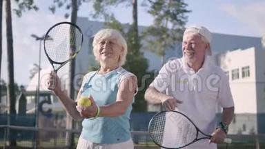 肖像快乐的成年夫妇在阳光明媚的<strong>日</strong>子打网球。 一个老男人<strong>和</strong>一个成熟的女人喜欢这个游戏。 康乐及<strong>文化</strong>事务署