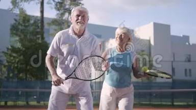 肖像快乐的成年夫妇在阳光明媚的<strong>日</strong>子打网球。 一个老男人<strong>和</strong>一个成熟的女人喜欢这个游戏。 康乐及<strong>文化</strong>事务署