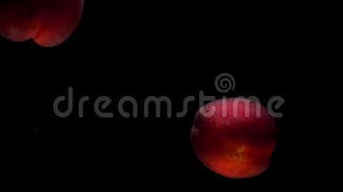 两个熟透的桃子在黑底透明的水<strong>底下</strong>