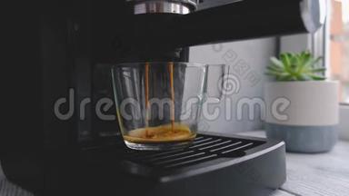 咖啡机在玻璃透明咖啡杯中制作浓缩咖啡。