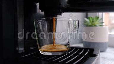 咖啡机在玻璃透明咖啡杯中制作浓缩咖啡。