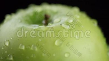 在视频中，我们看到一个绿色的苹果，在视频的中间，水开始从顶部像淋浴一样倾泻下来，黑色的。