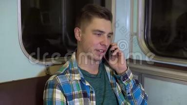 一个年轻人在地铁列车上打电话。 旧地铁车
