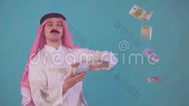 画像上的阿拉伯男人留着胡子，穿着奥迪的传统服装，扔钱