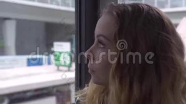肖像年轻女子在现代城市街道上骑车时看着车窗<strong>客车</strong>。 坐着的漂亮女人