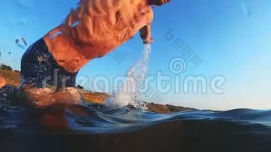 一个成年男子在日落时跳进水里。 一个人跳进水里，在水下游泳。 夏季活动