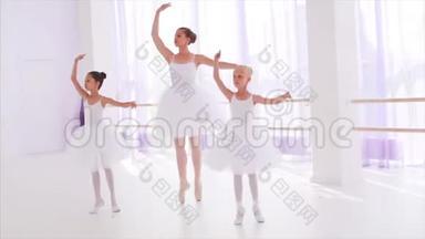 芭蕾舞老师带着小<strong>孩子在上课</strong>时踮起脚尖跳舞.