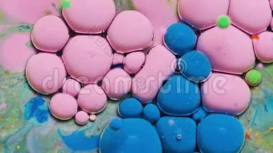 蓝色和粉红色的油墨反应形成一个美丽的结构油漆气泡。