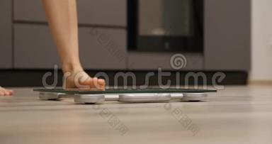 女足站在房间里的秤上。 女人的腿踩在秤上。 人类在秤上测量体重。 减肥概念