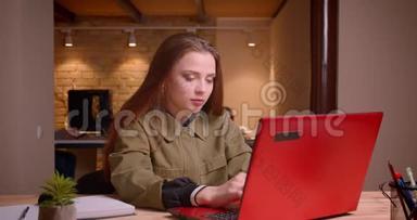 年轻少女用笔记本电脑工作的肖像获得成功在办公室获得快乐。