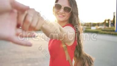 观点。 幸福的年轻女人牵着男朋友的手在城里散步的肖像。 幸福家庭