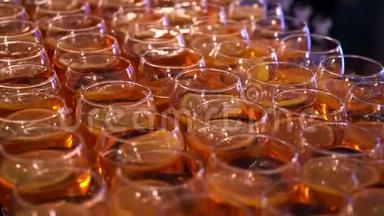 酒吧柜台上有很多酒杯。 <strong>橙色</strong>饮料，里面有一块<strong>橙色</strong>的鸡尾酒杯