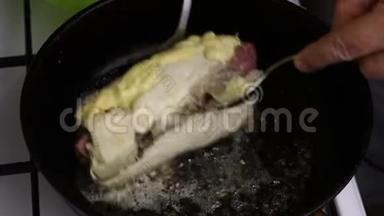 在一个加了黄油的加热煎锅里，鸡角卷被炸了。 一个人用叉子<strong>翻卷</strong>。 你可以看到石油是怎样的