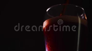 浇筑柯拉慢动作特写.. 杯子里有气泡的可乐。 可乐汽水在黑色背景下特写。 慢动作