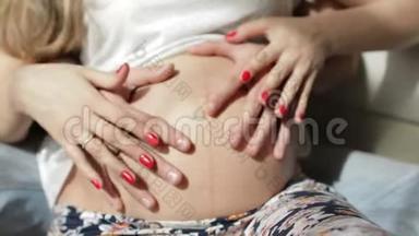 <strong>爸爸妈妈</strong>把手放在怀孕的肚子上。 怀孕夫妇抚摸怀孕的肚子。