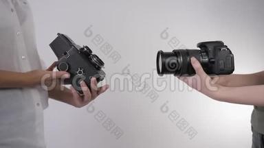 老式照片，专业照相馆将旧胶卷相机与现代数码相机相比较