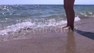 女人的脚站在<strong>沙滩上</strong>，海浪拍打着她的脚在日出的<strong>海边</strong>慢动作美丽的<strong>海边</strong>镜头