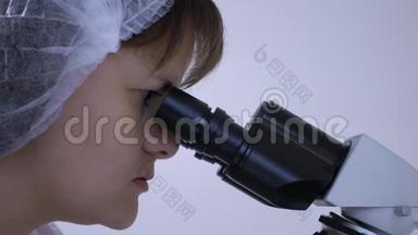 女化验员克劳瑟普盯着显微镜的目镜