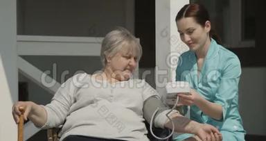 在阳光明媚的日子里，护士在养老院拍摄的照片上微笑和照顾老人出门